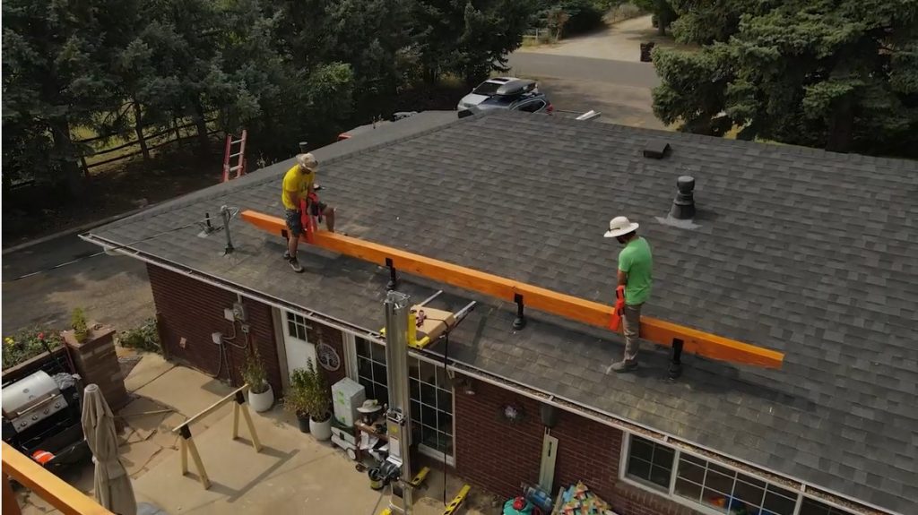 Wooden beam being attached to the roof via the roof risers.