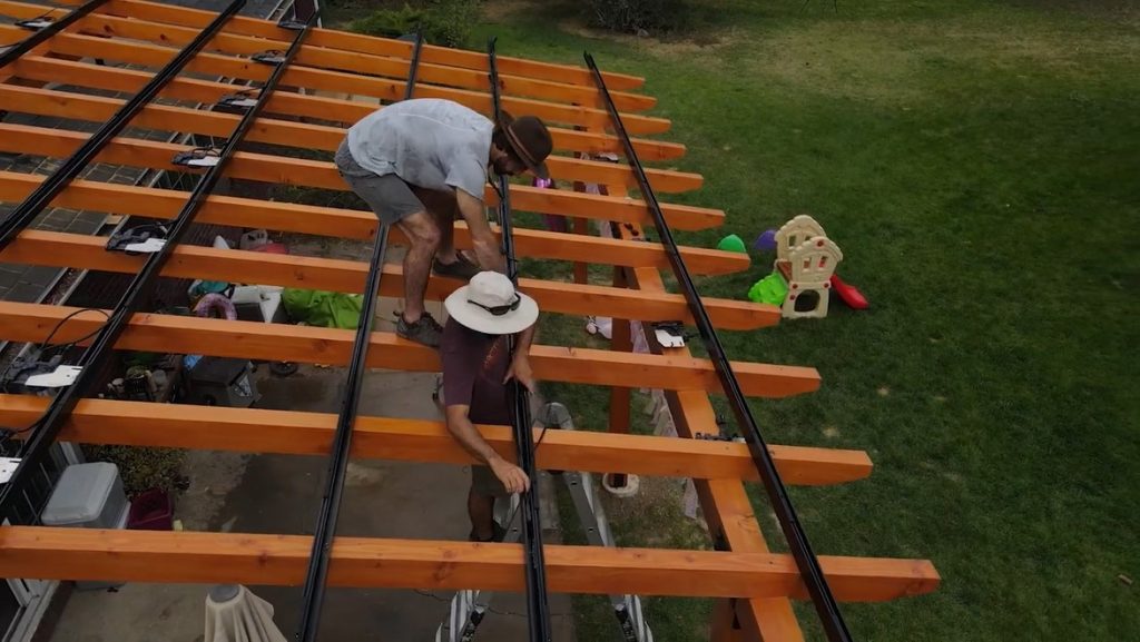 Laying down trunk cabling via the racking on a solar pergola.
