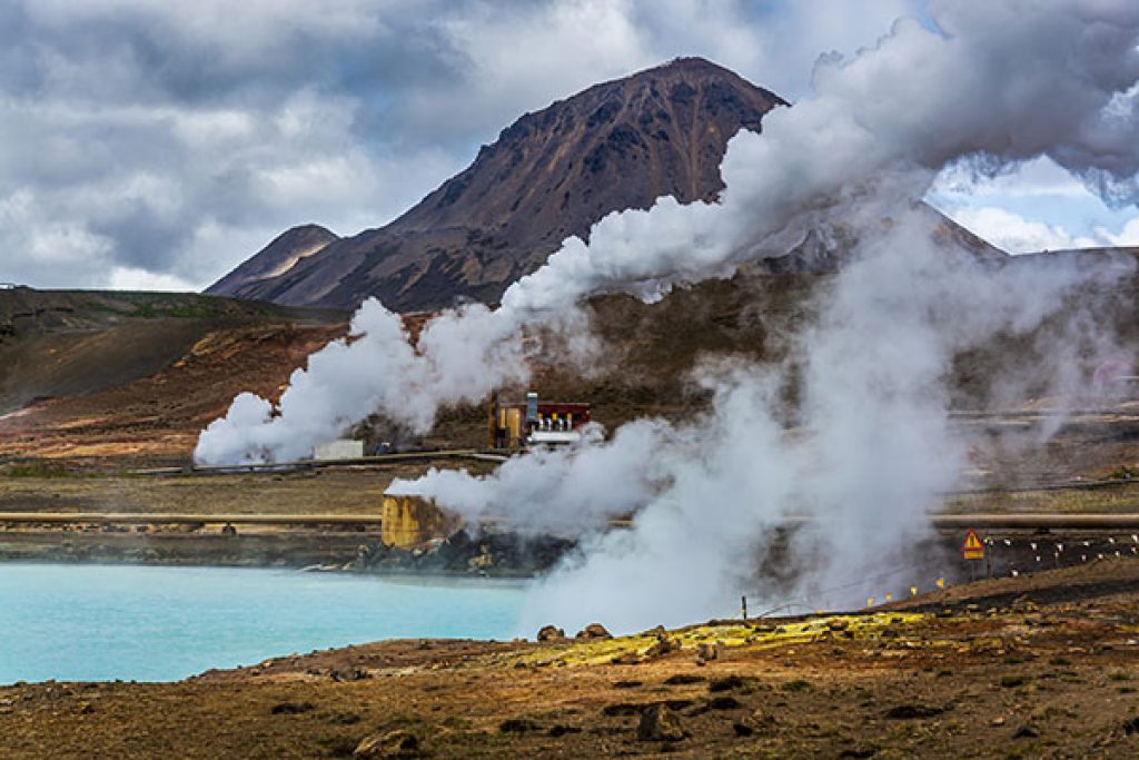 A geothermal power plant alongside a geothermal pool. 