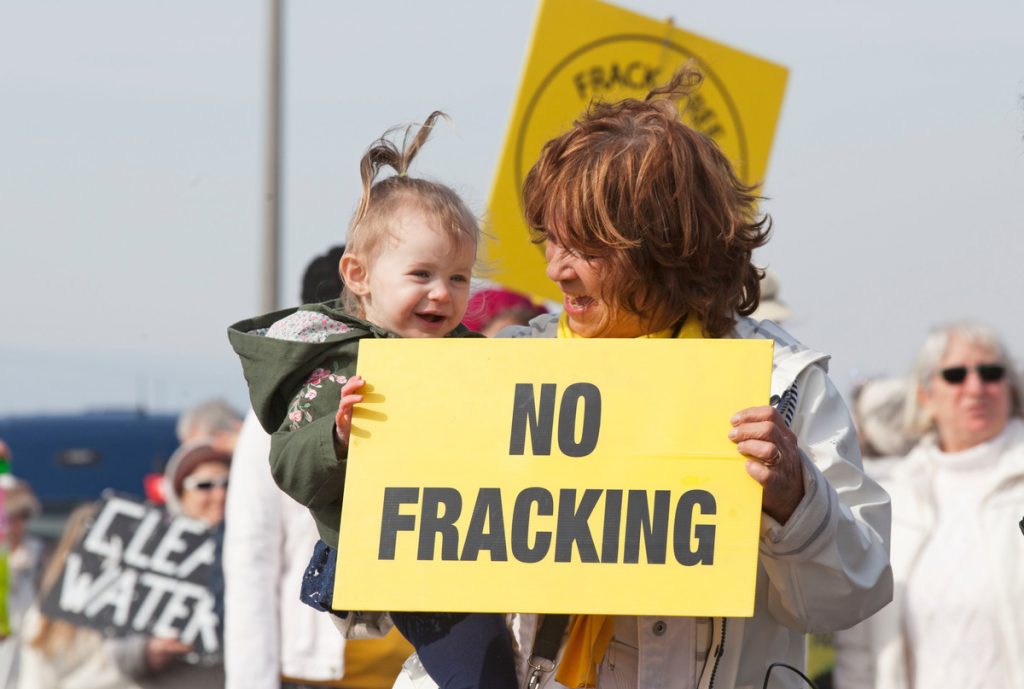 Local woman and child protesting against new fracking in the UK.