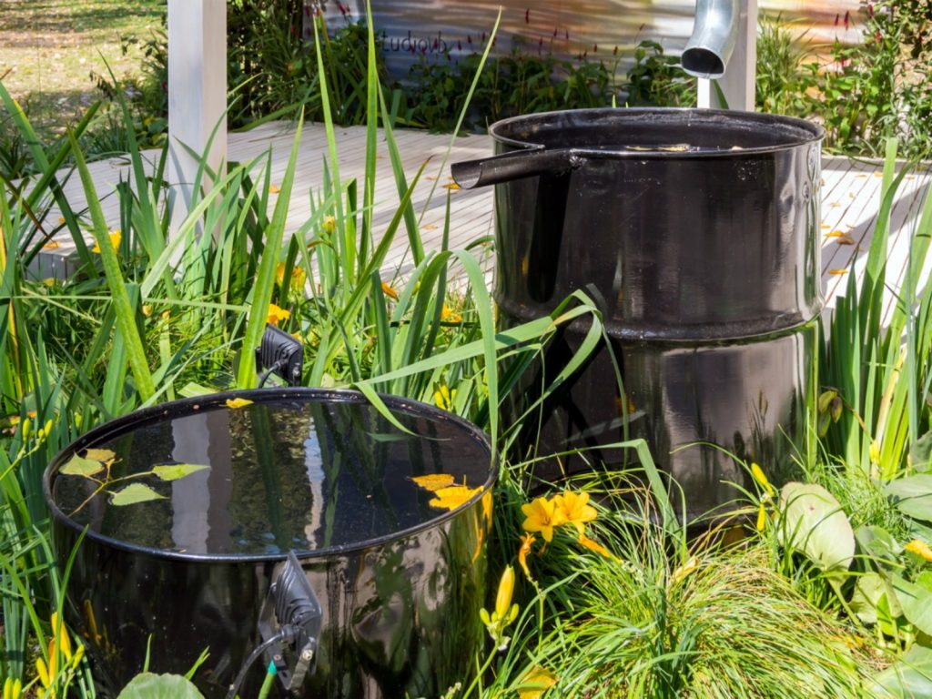 These barrels act as a water feature and water the garden when they overflow. It's a great design! 