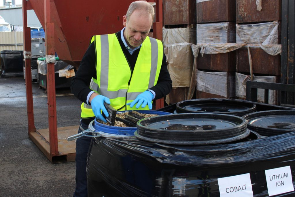 Man inspecting batteries for recycled materials.