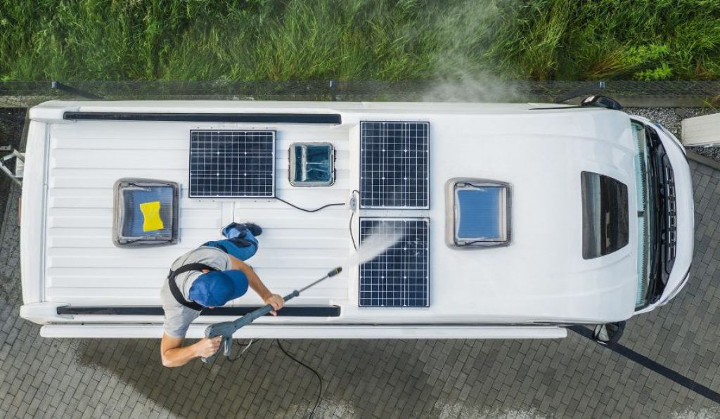 man washing off RV solar panels