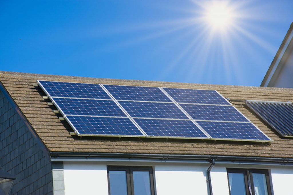 60-cell solar modules mounted on the roof of a house on a sunny day. 