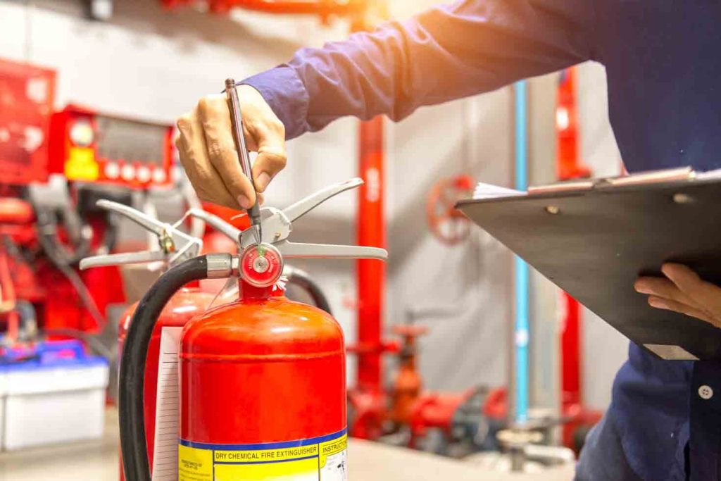 Engineer conducting a safety check on a fire extinguisher.
