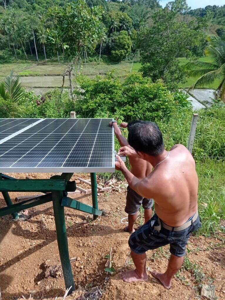 Putting final end-clamps on ground-mounted solar structure.